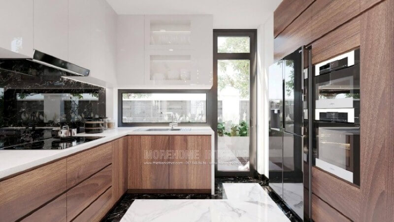 Là một trong những xu hướng thiết kế nội thất nổi bật trong những năm tới, bố trí phòng bếp hiện đại tôn lên vẻ đẹp mộc mạc nhưng không kém phần sang trọng của gỗ điển hình là gỗ óc chó. Loại gỗ rất được ưa chuộng trong các siêu xe bởi vẻ đẹp ấn tượng từ vân, màu gỗ. Như trong ý tưởng thiết kế phòng bếp tại biệt thự Vinhomes Imperia, sự hài hòa tôn lên nét đẹp giữa truyền thống và hiện đại, tủ bếp dưới gỗ óc chó veneer và tủ bếp trên acrylic trắng bóng. Tủ bếp gỗ công nghiệp và tủ bếp acrylic